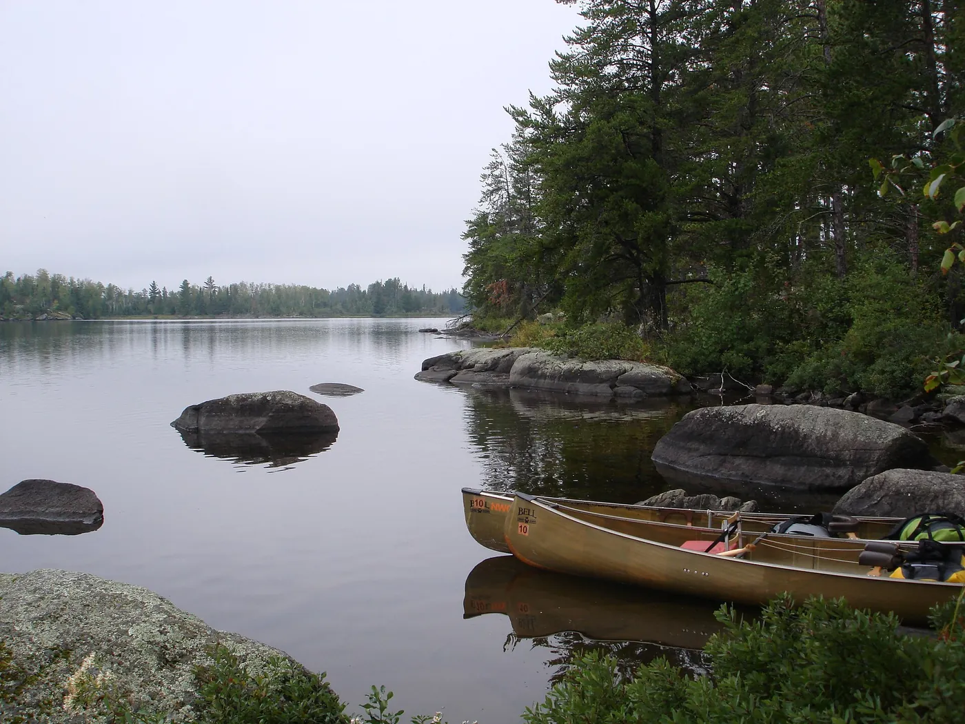 Canoes resting on the rocks of a quiet Boundary Waters lake