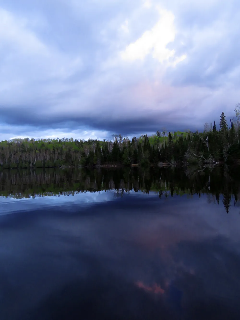 A north woods lake at dusk under a soft violet sky